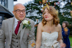 A close up of bride and groom having a confetti shot