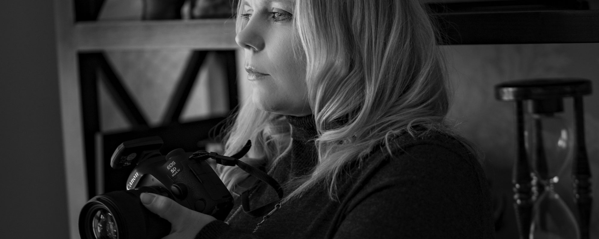 Profile Image – Emma Lowe Profile image of Emma Lowe, Professional Photographer with camera in hand - black and white.
